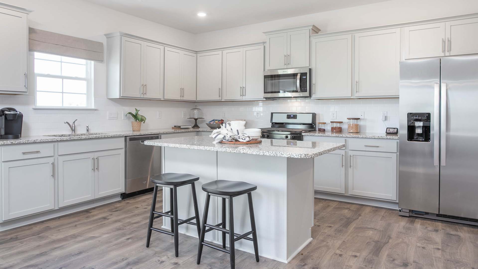 kitchen with island, revwood floors and stainless steel appliances