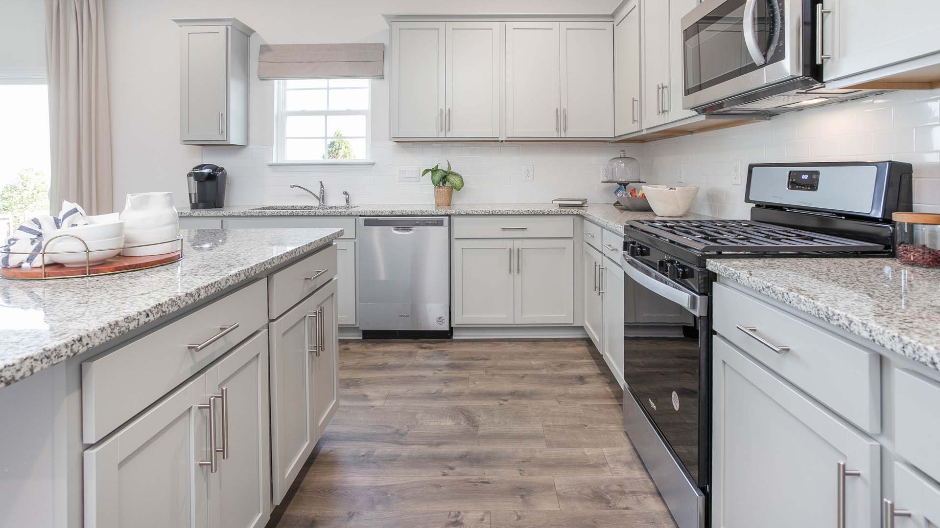 kitchen with island, revwood floors and stainless steel appliances