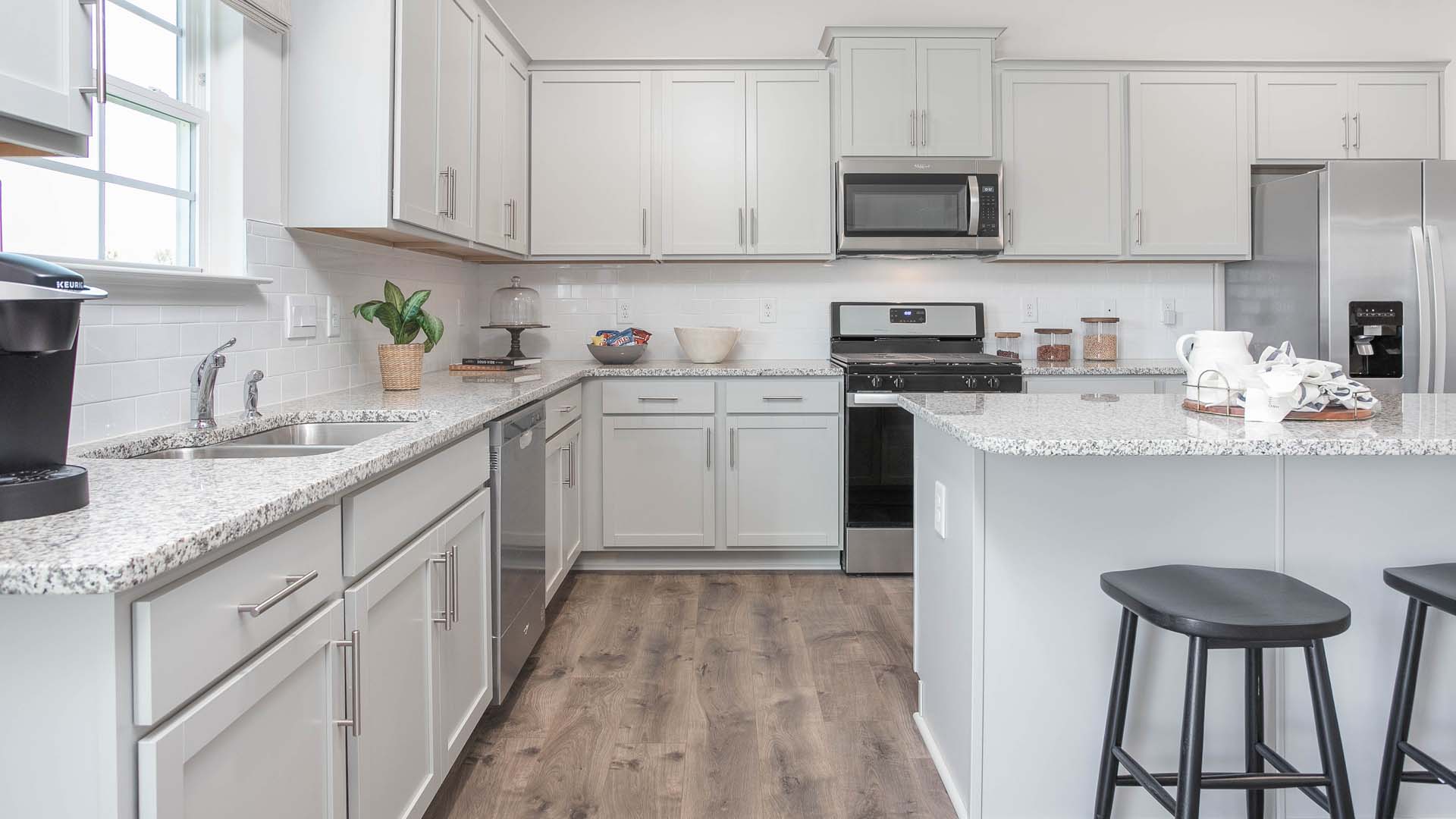 kitchen with island, revwood floors and stainless steel appliances