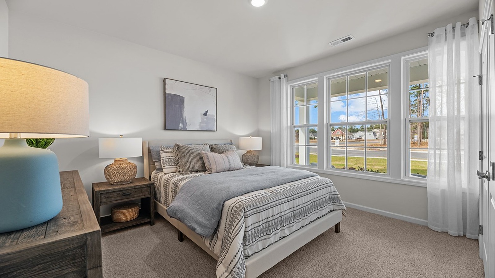 front bedroom with double window and carpet flooring