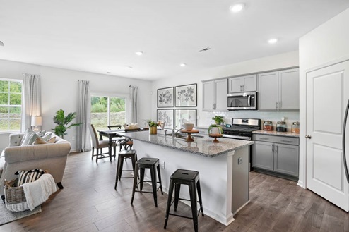 kitchen with island and revwood floors with stainless steel appliances