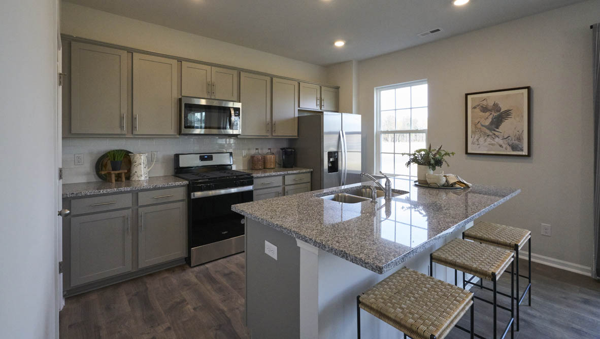 kitchen with island and revwood floors with stainless steel appliances
