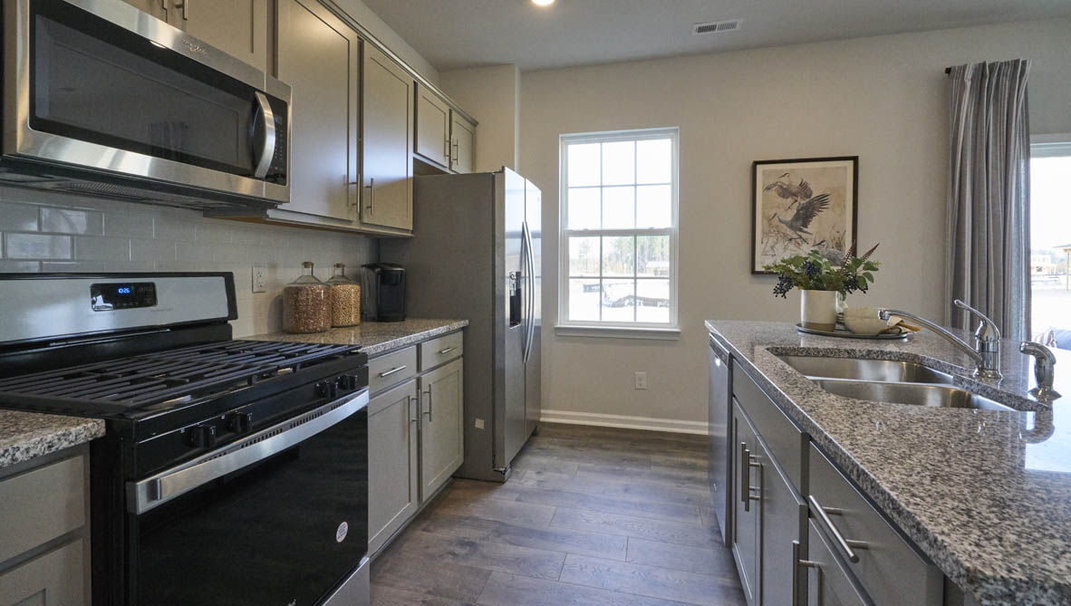 kitchen with island and revwood floors with stainless steel appliances
