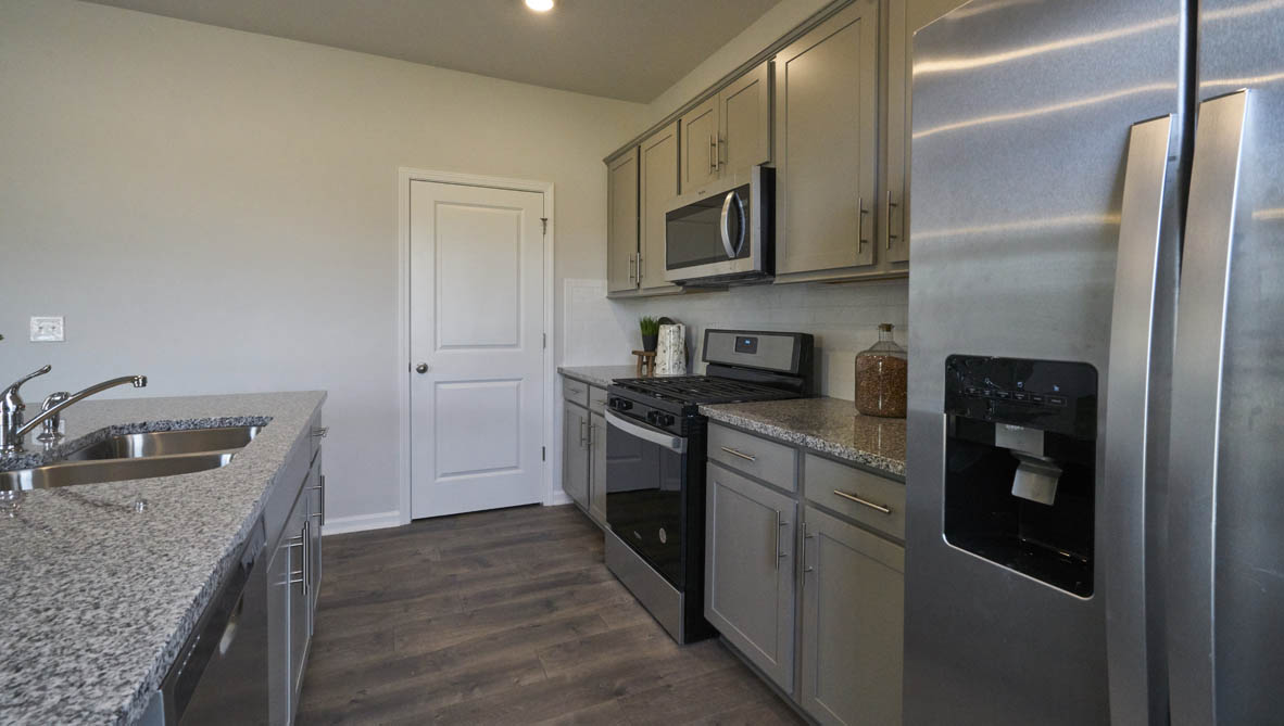 kitchen with island and revwood floors with stainless steel appliances