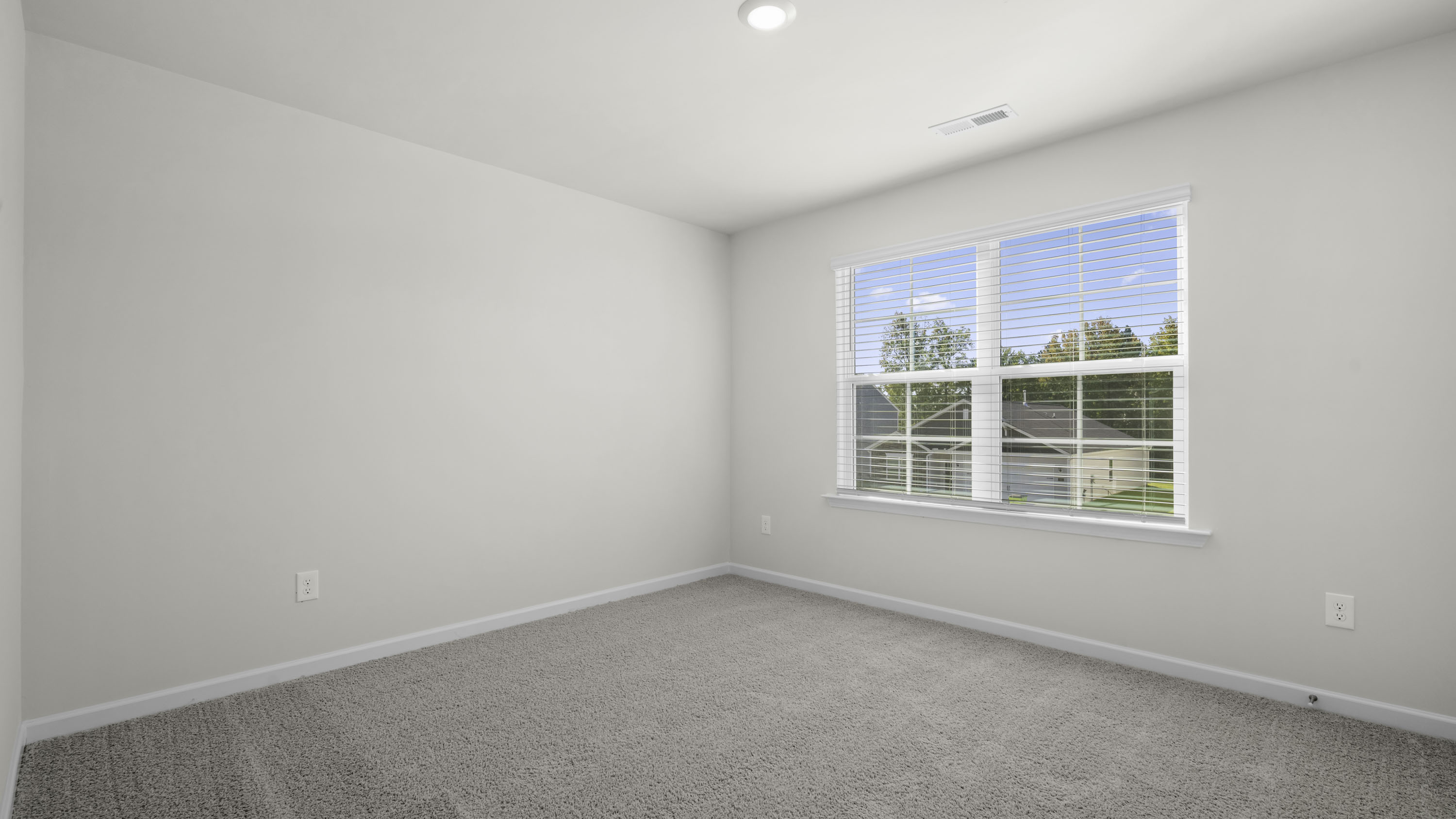 Neutral-toned walls, high-pile carpeting, recessed lighting, and a dual-pane window with installed blinds