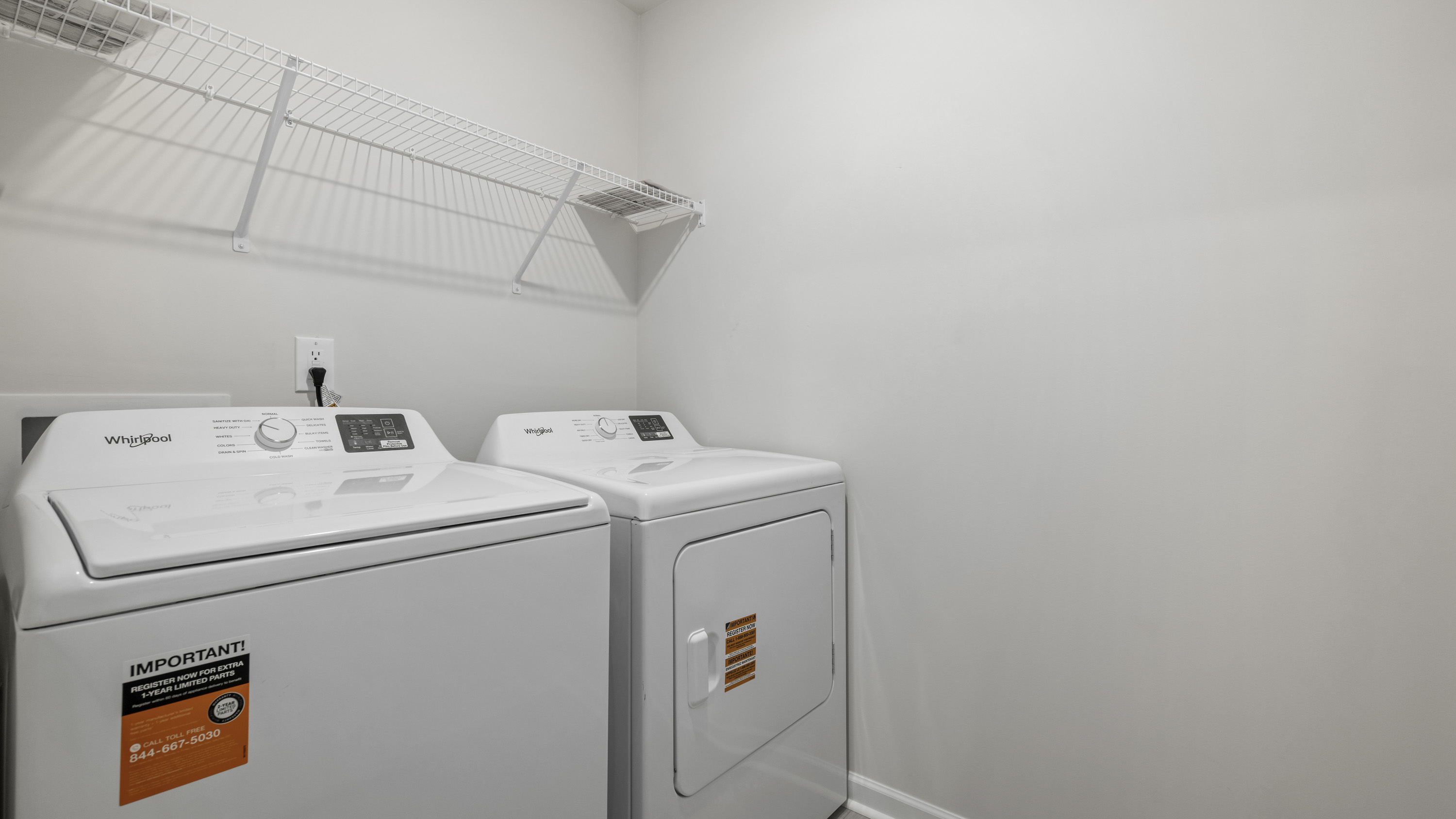 Laundry area featuring white appliance hookups and built-in wire shelving
