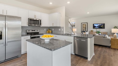 kitchen with island and revwood floors and stainless steel appliances