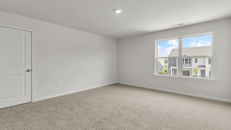 primary bedroom with carpet and window