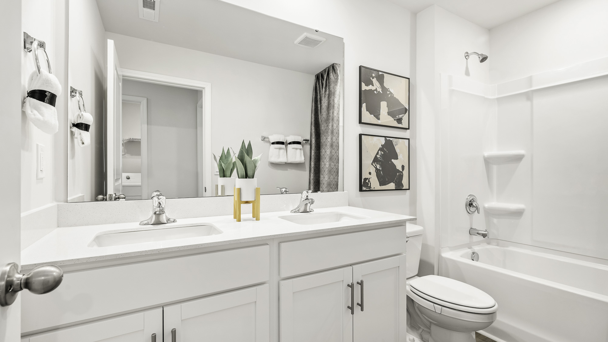 secondary bathroom with dual sink and tub shower combo