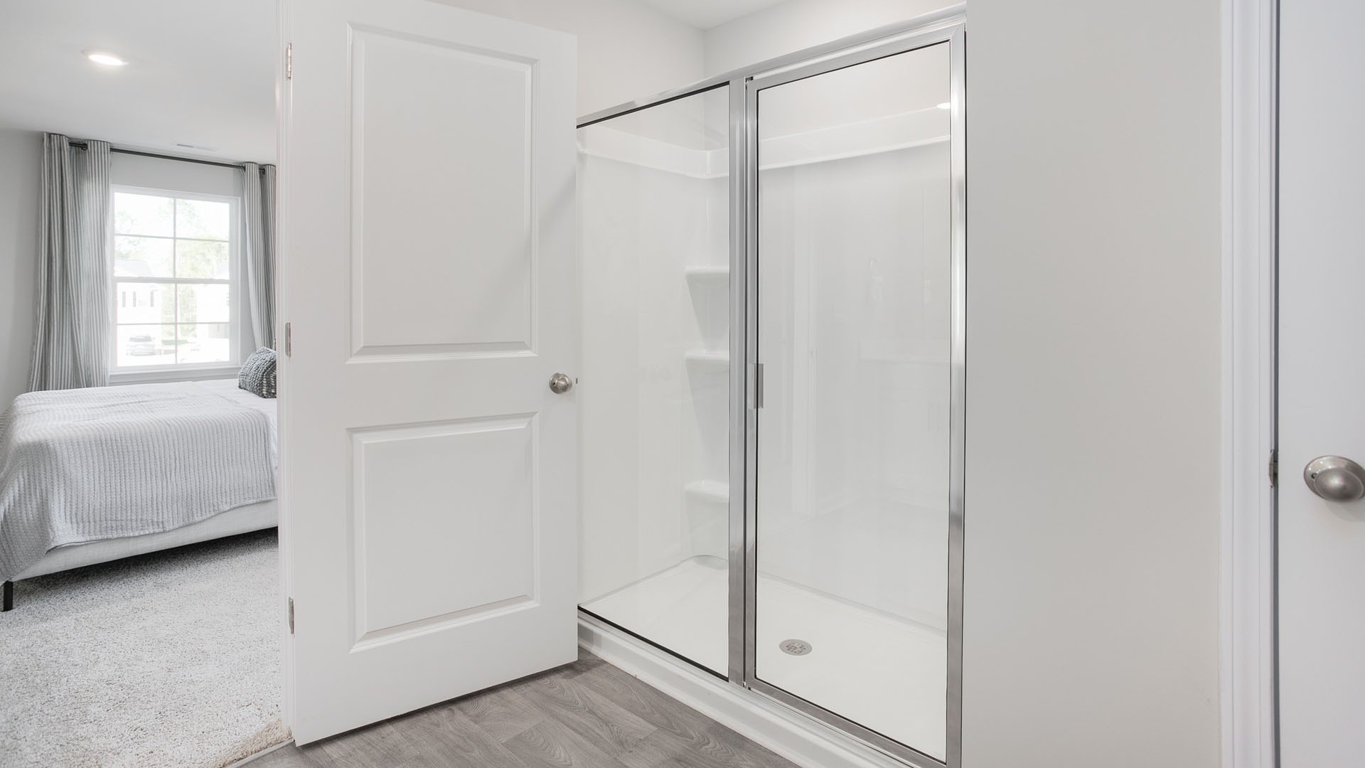 priamry walk in shower and view of bedroom