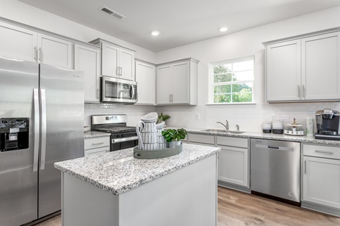 kitchen with revwood floors an island and stainless steel appliances