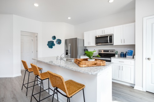 kitchen with revwood floors an island and stainless steel appliances
