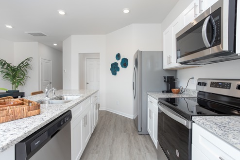 kitchen with revwood floors an island and stainless steel appliances