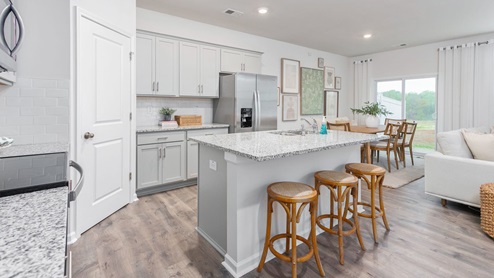 kitchen with revwood floors an island and stainless steel appliances