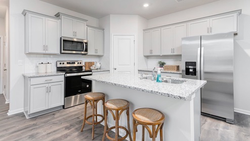 kitchen with revwood floors an island and stainless steel appliances