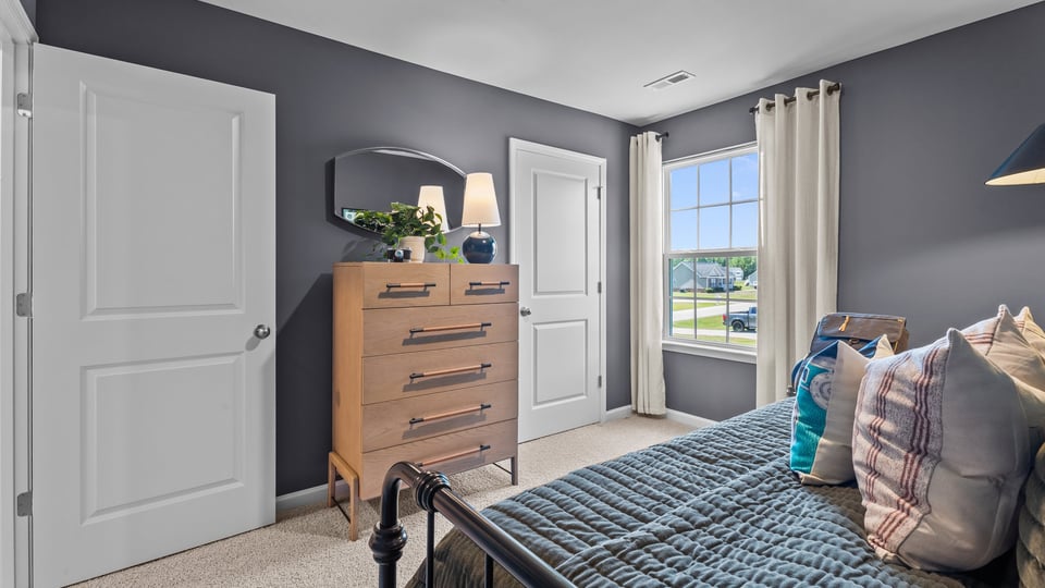 secondary bedroom with closet and window