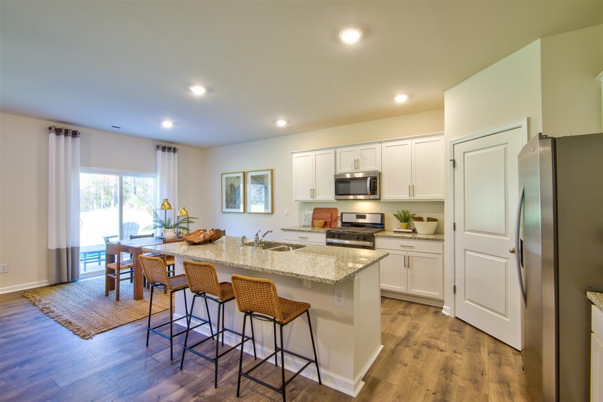 kitchen with vinyl floor, an island, and stainless steel appliances