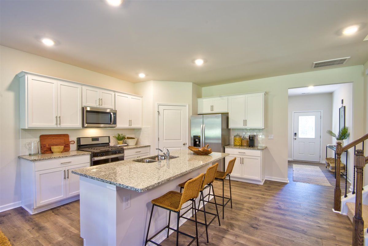kitchen with vinyl floor, an island, and stainless steel appliances