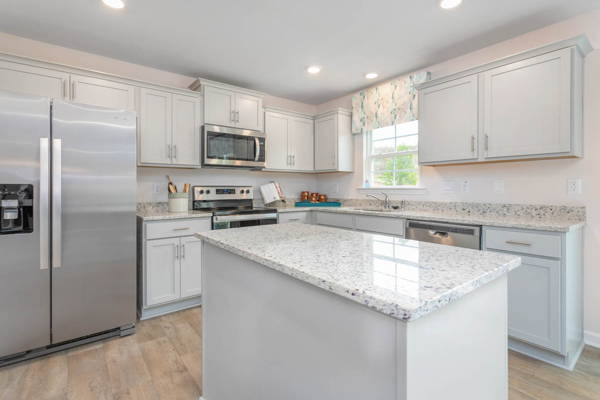 kitchen with vinyl floor, and island, and stainless steel appliances