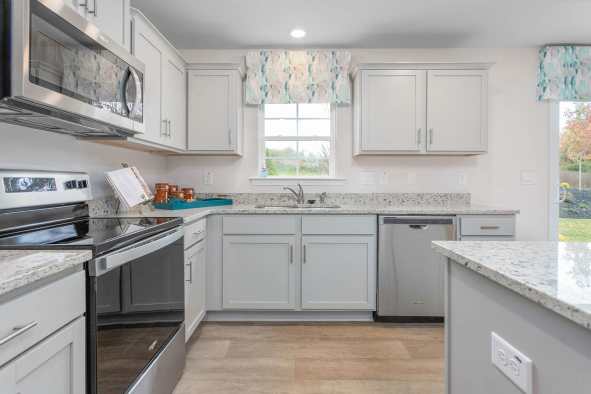 kitchen with vinyl floor, and island, and stainless steel appliances