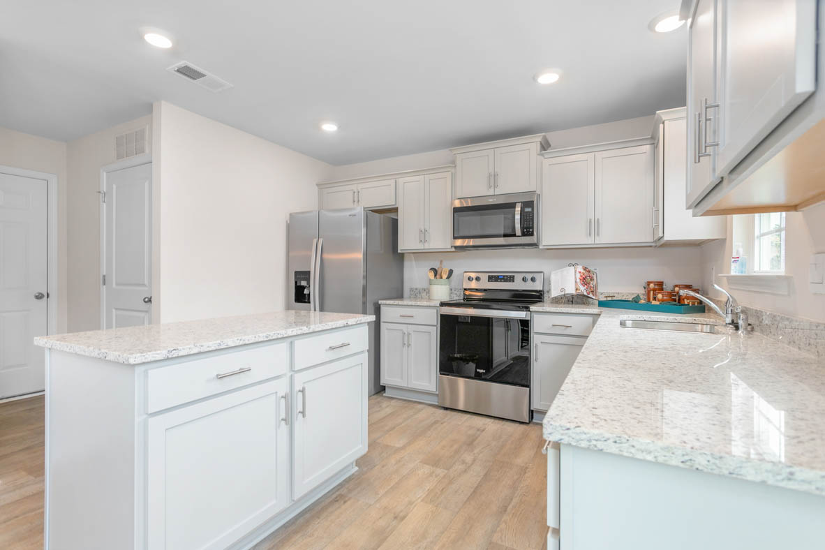 kitchen with vinyl floor, and island, and stainless steel appliances