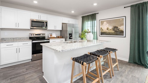 Kitchen with vinyl flooring, stainless steel appliances, an island and shaker style cabinets