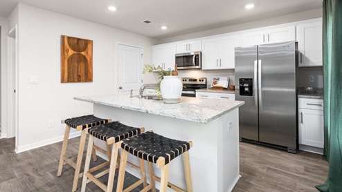 Kitchen with vinyl flooring, stainless steel appliances, an island and shaker style cabinets