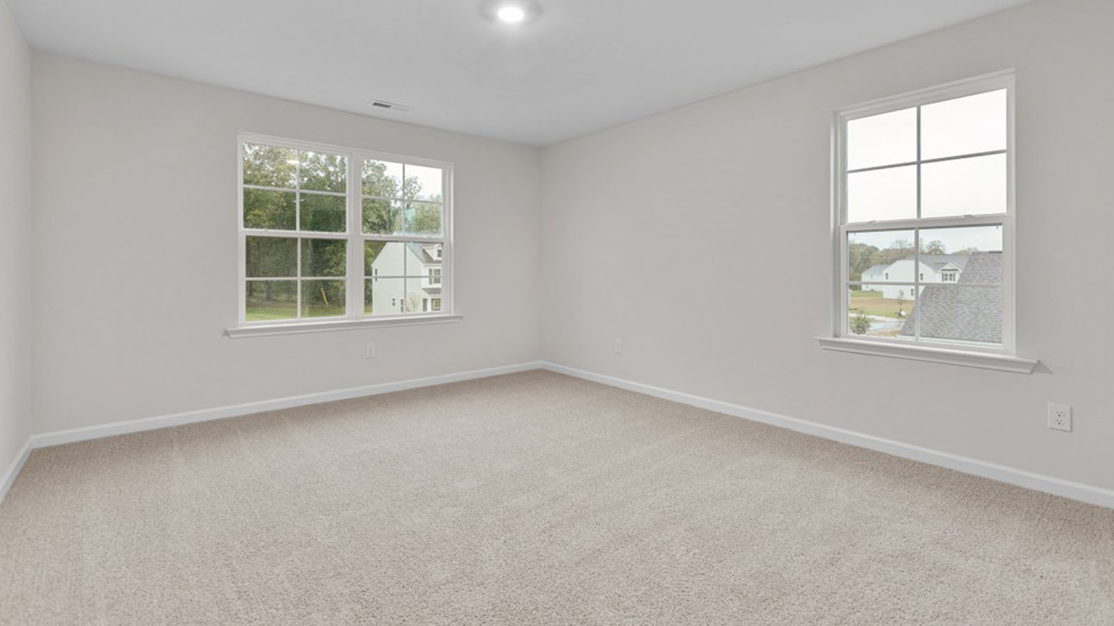 secondary bedroom with carpet and windows
