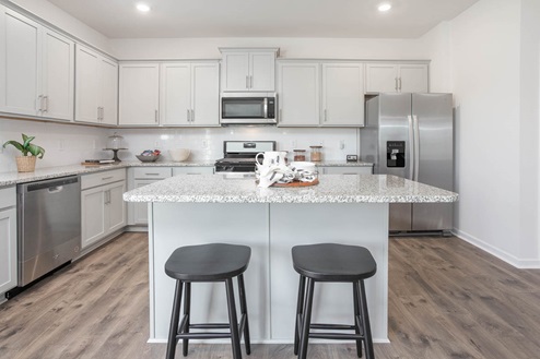 kitchen with revwood floors an island and stainless steel appliances