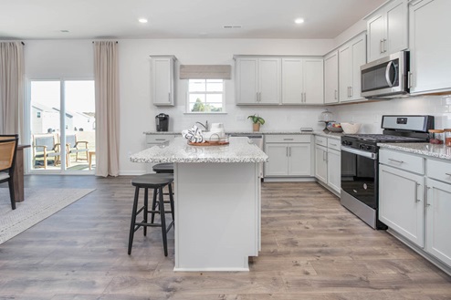 kitchen with revwood floors an island and stainless steel appliances