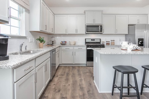 kitchen with revwood floors an island and stainless steel appliances
