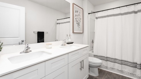 bathroom with tub, vinyl flooring and double vanity
