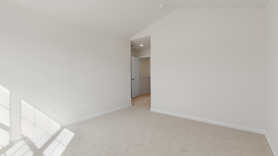 Interior room featuring vaulted ceilings, neutral wall paint, and wall-to-wall carpeting