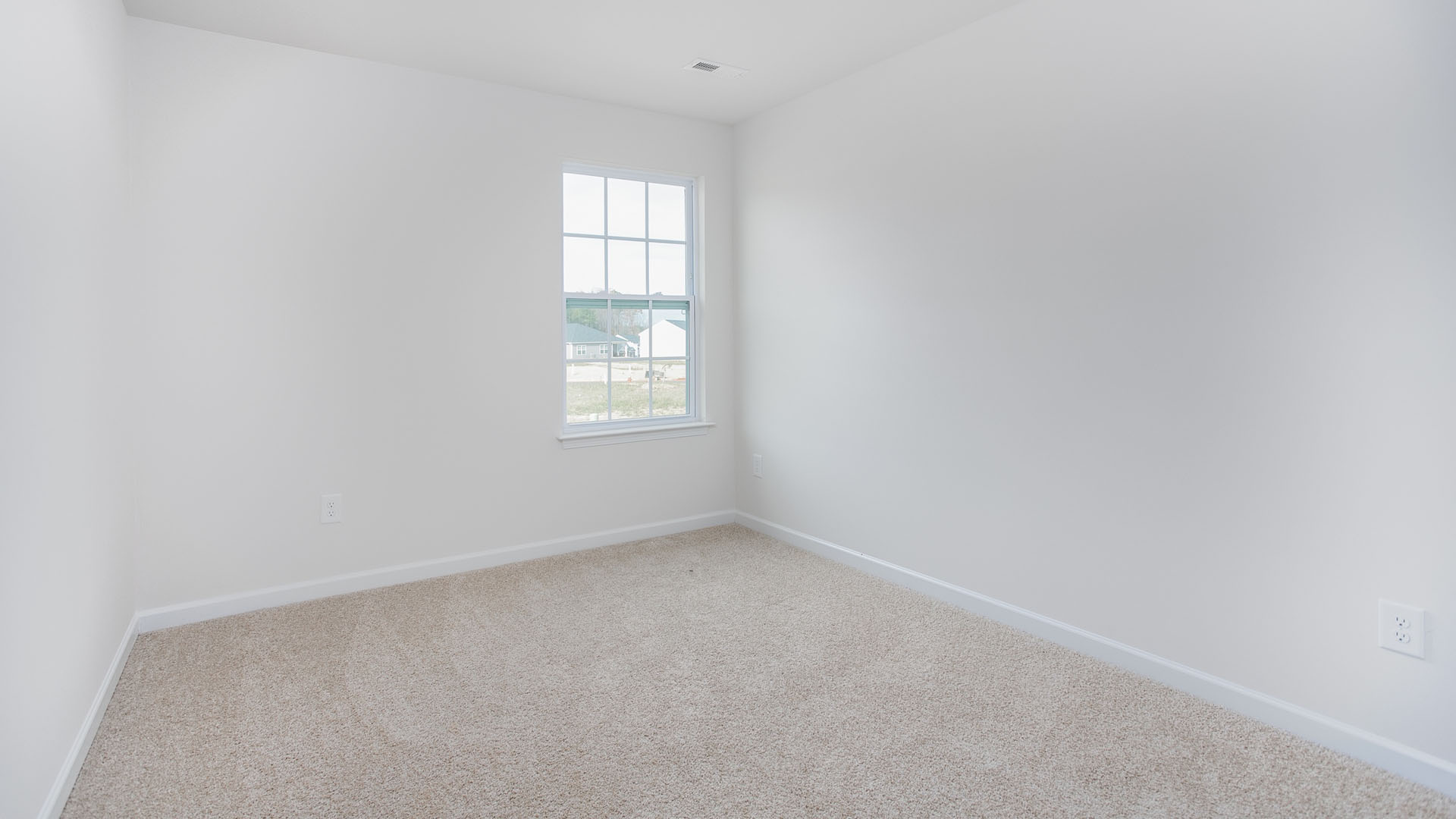 Neutral wall tones, wall-to-wall carpeting, and a multi-pane window