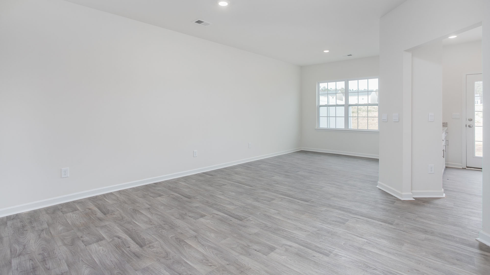 Neutral interior space featuring wood-finish flooring, recessed lighting, and multi-pane windows