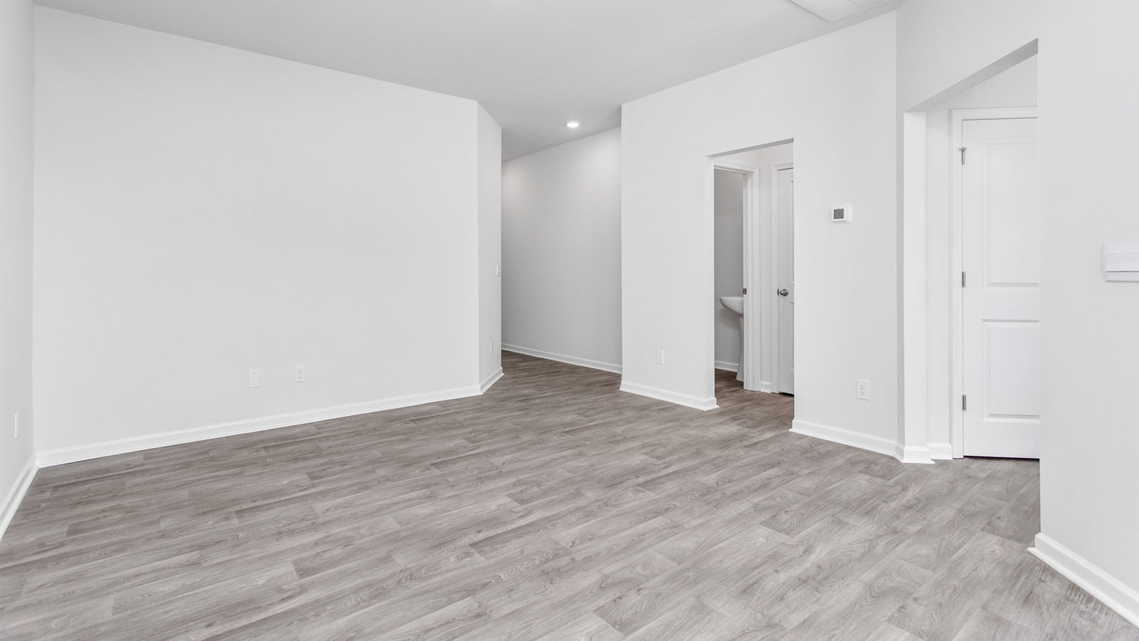 Interior space featuring wood-finish flooring, neutral walls, recessed lighting, and white multi-panel interior doors