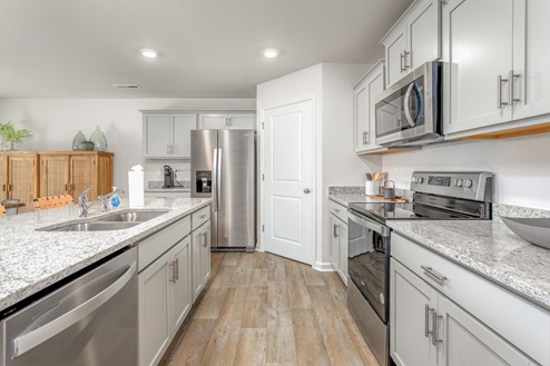 kitchen with vinyl floors an island and stainless steel appliances