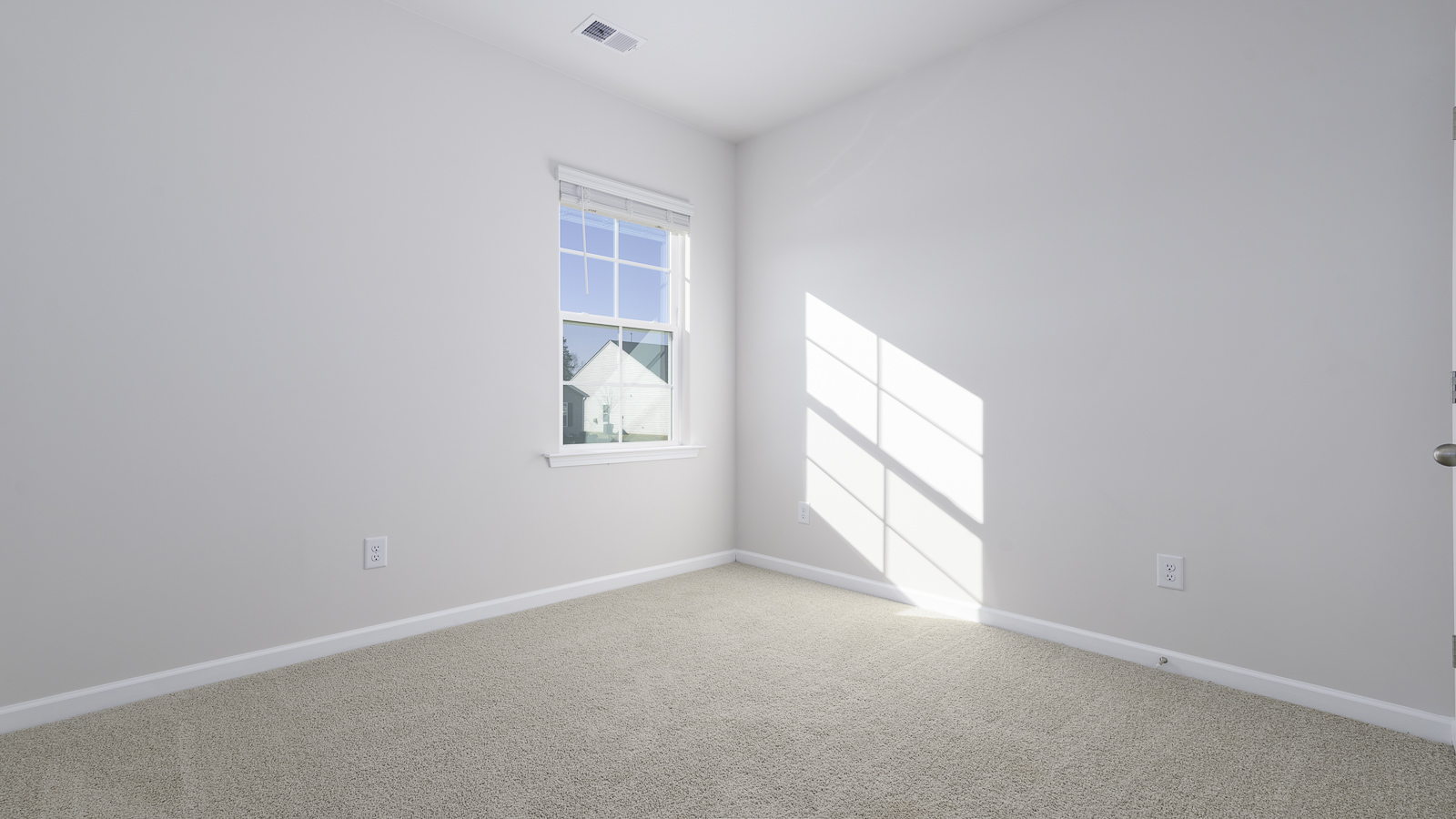 secondary bedroom with window and carpet