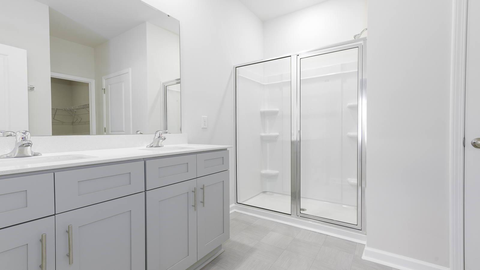 primary bathroom with double sinks and walk in shower