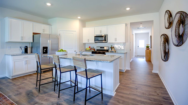 Kitchen with Revwood flooring, and island, and stainless steel appliances