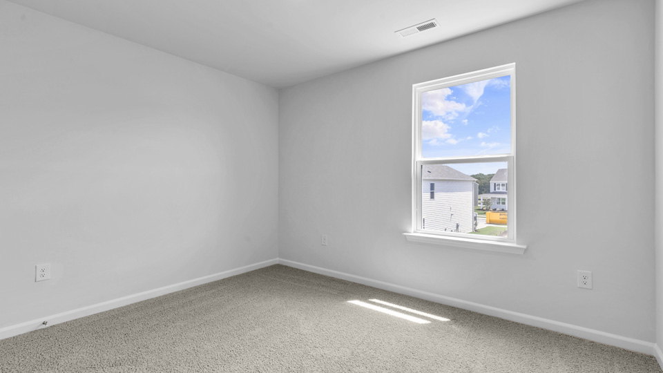 secondary bedroom with carpet and window