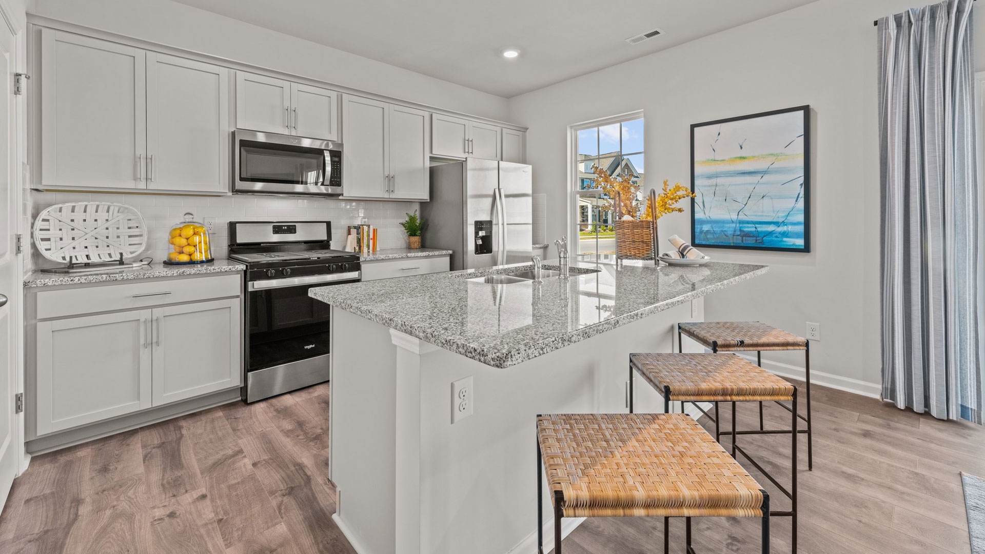 kitchen with revood flooors, island and stainless steel appliances