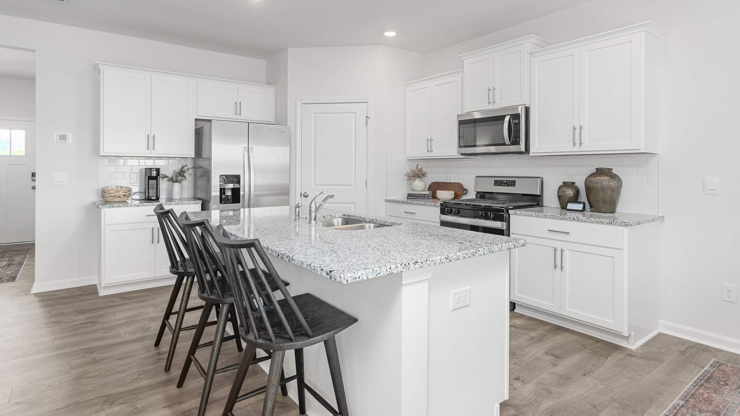kitchen with revwood floors, an island, and stainless steel appliances