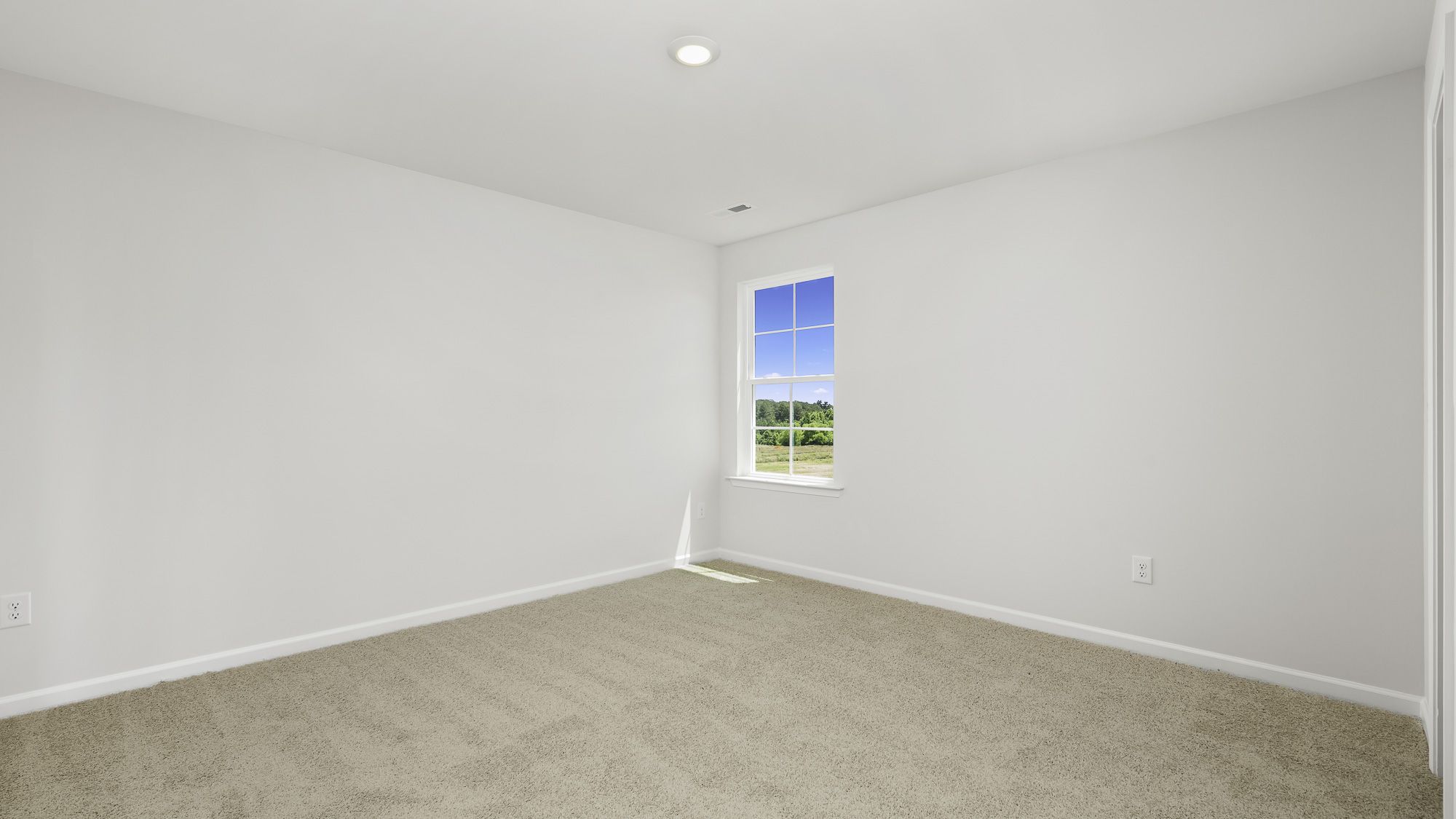 Neutral wall-to-wall carpeting, crisp white interior walls, recessed lighting, and a single-hung window with exterior landscape exposure