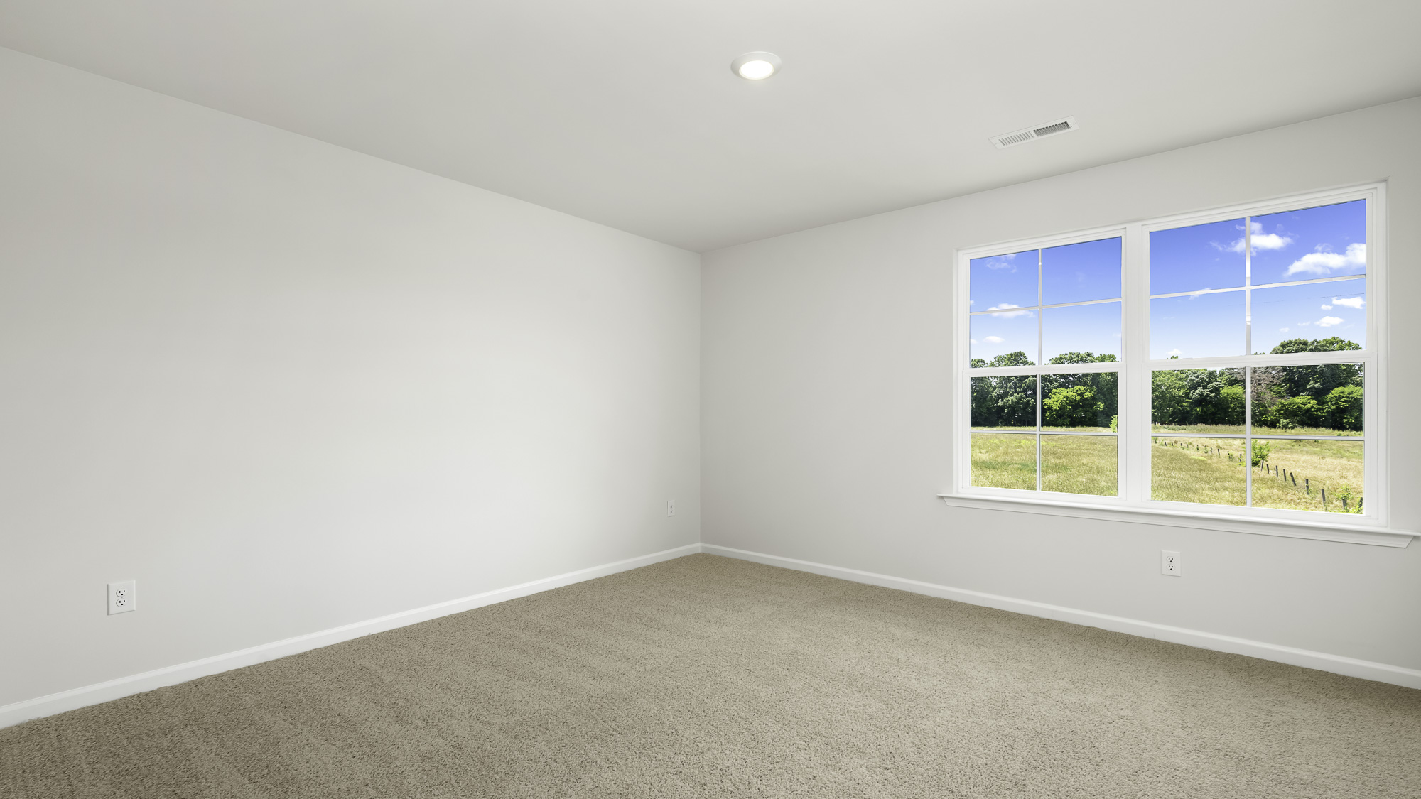 Neutral-toned carpeted flooring, smooth wall finish, recessed lighting, and a dual-pane window with grid inserts