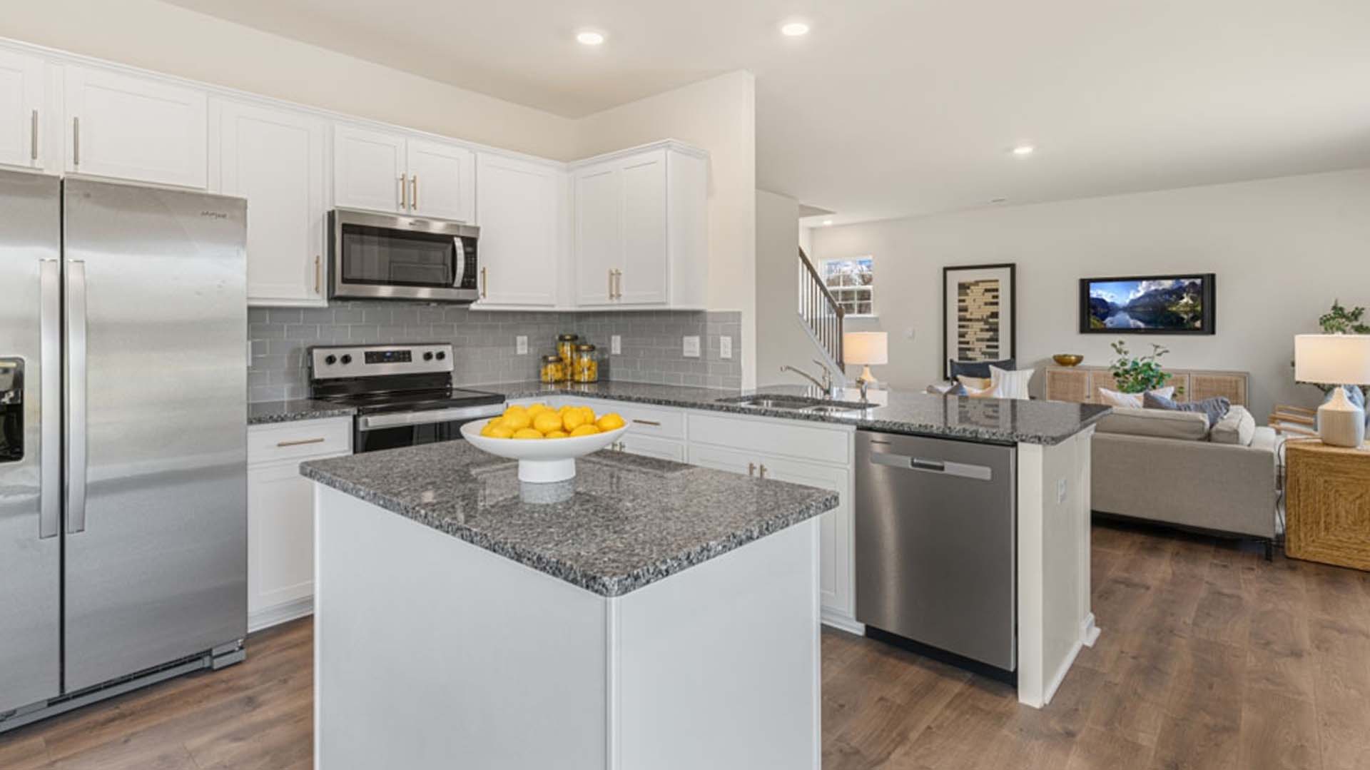 kitchen with island and revwood floor, with stainless steel appliances
