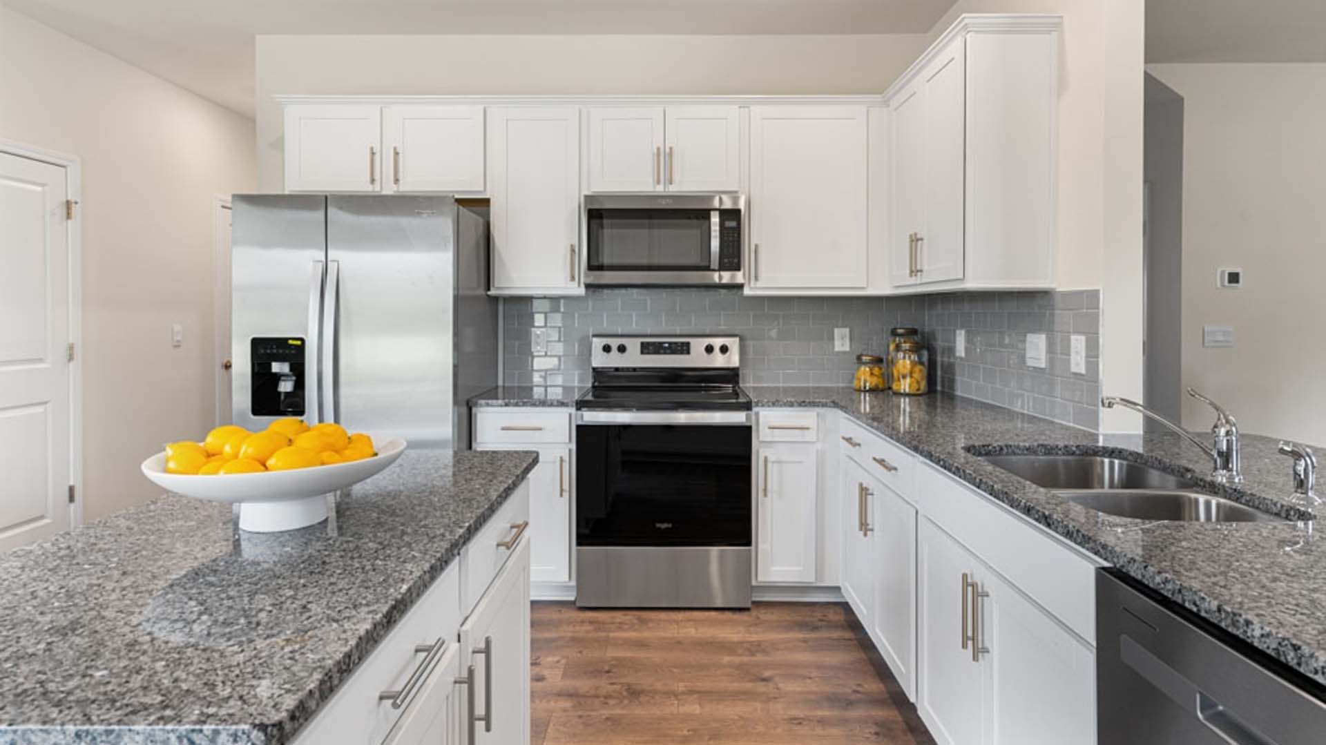 kitchen with island and revwood floor, with stainless steel appliances