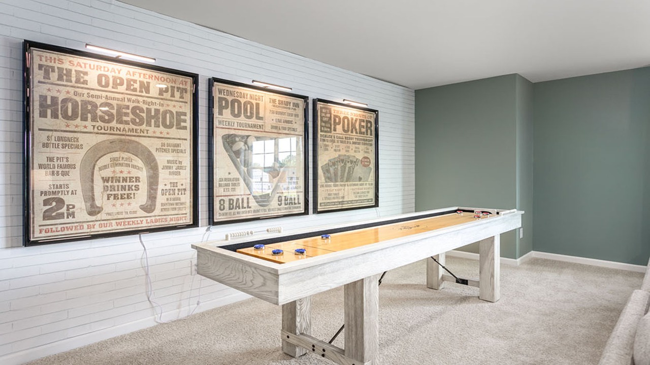 Painted brick accent wall with wall-mounted picture lights and neutral carpeting