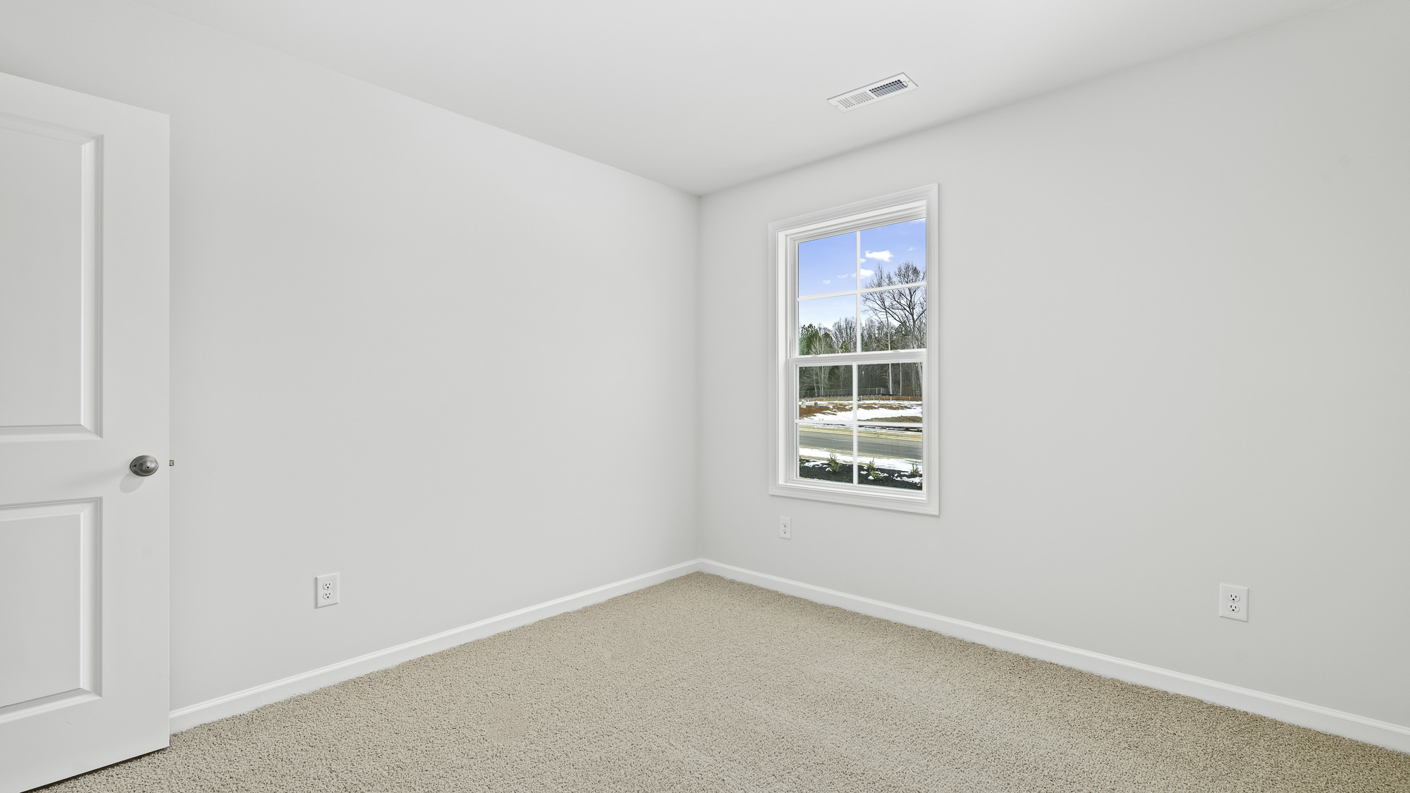 bedroom with one window and tan carpet