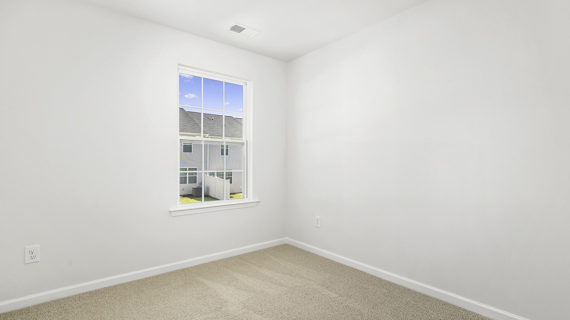 secondary bedroom with carpet and window